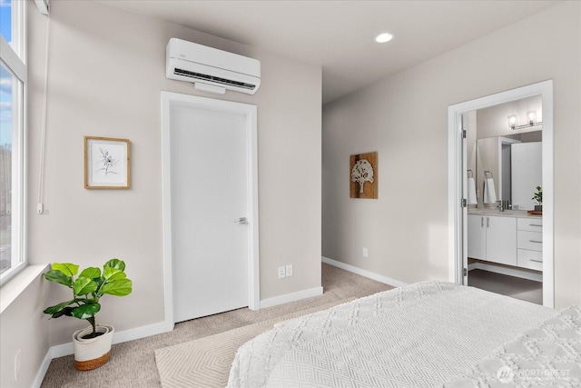 carpeted bedroom featuring ensuite bathroom, baseboards, multiple windows, and a wall mounted air conditioner