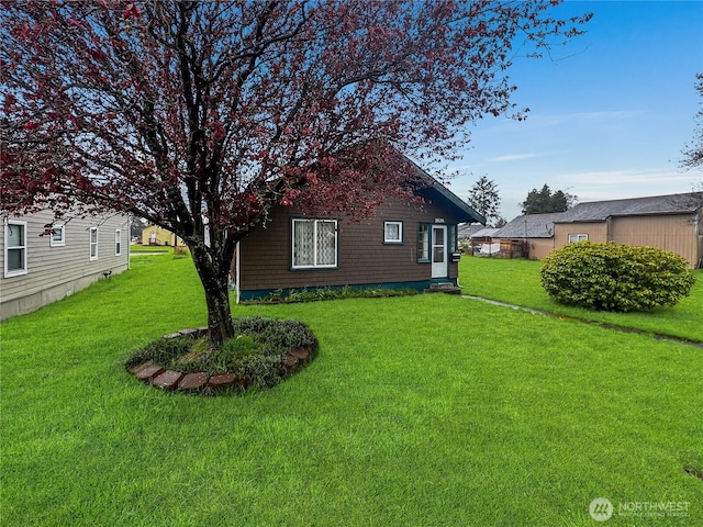 view of side of home with a yard