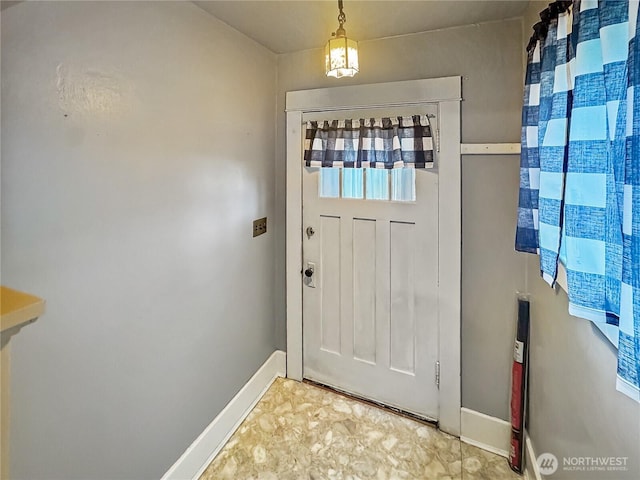 doorway to outside with baseboards