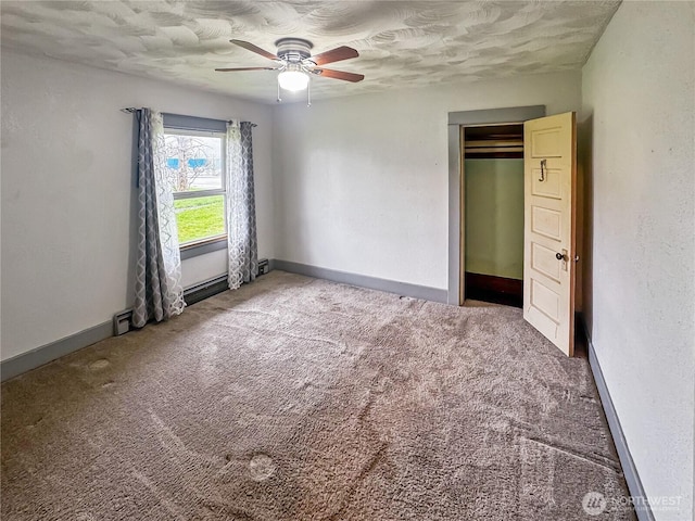 unfurnished bedroom featuring a textured ceiling, baseboards, a ceiling fan, and carpet