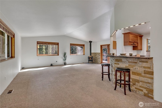 28529 298th Pl SE, Ravensdale, WA 98051 - interior space featuring visible vents, a wood stove, light colored carpet, and lofted ceiling