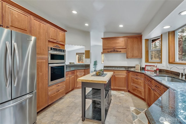 28529 298th Pl SE, Ravensdale, WA 98051 - kitchen with dark stone counters, recessed lighting, a sink, stainless steel appliances, and brown cabinets