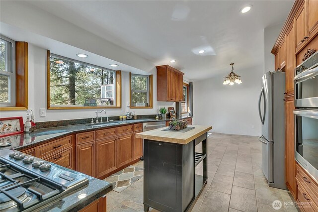 28529 298th Pl SE, Ravensdale, WA 98051 - kitchen featuring brown cabinetry, a chandelier, a sink, stainless steel appliances, and wooden counters