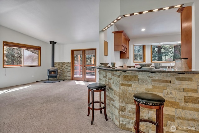 28529 298th Pl SE, Ravensdale, WA 98051 - kitchen with a wood stove, plenty of natural light, light colored carpet, and a breakfast bar area
