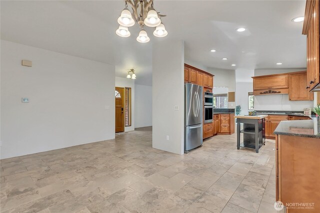 28529 298th Pl SE, Ravensdale, WA 98051 - kitchen featuring dark stone countertops, a chandelier, brown cabinetry, recessed lighting, and stainless steel appliances