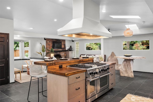 kitchen featuring double oven range, plenty of natural light, lofted ceiling with skylight, and island exhaust hood