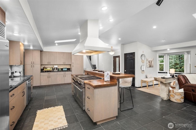 kitchen with a center island, appliances with stainless steel finishes, a kitchen breakfast bar, butcher block counters, and island range hood
