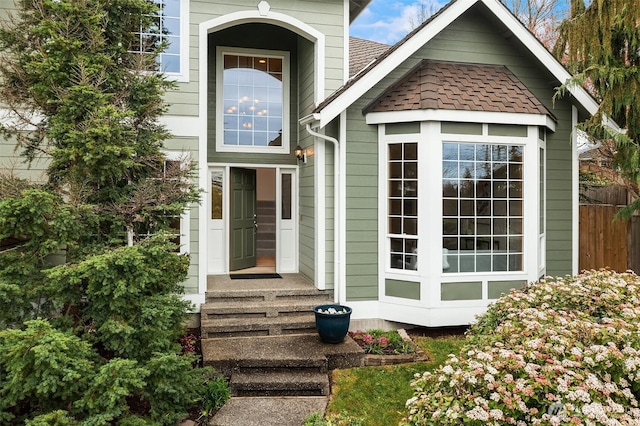 doorway to property with roof with shingles