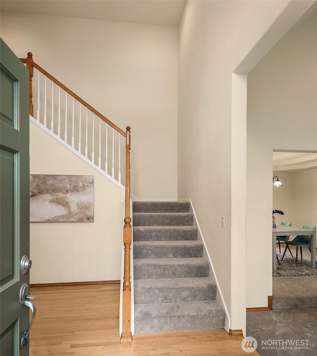 stairway featuring baseboards and wood finished floors