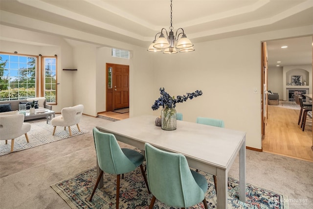 dining area featuring baseboards, an inviting chandelier, light carpet, recessed lighting, and a tray ceiling