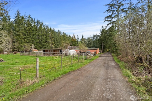 view of street with a wooded view and a rural view