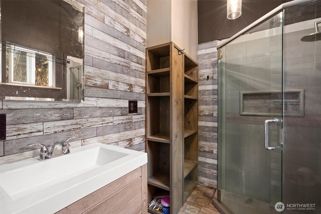 bathroom with a shower stall, wooden walls, and vanity