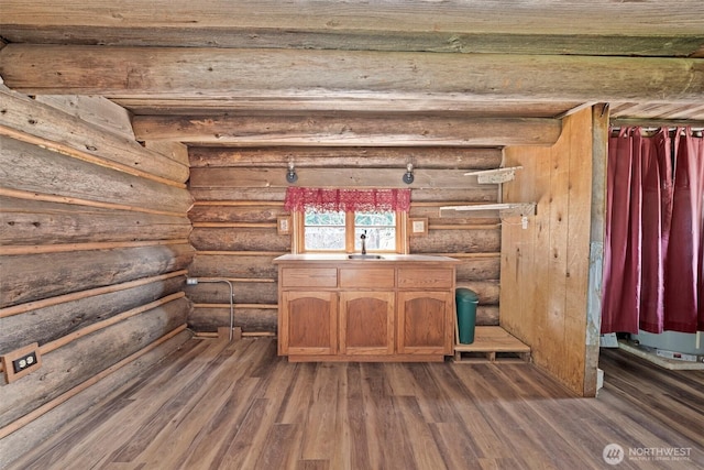 details featuring a sink, rustic walls, and wood finished floors