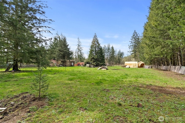 view of yard featuring fence and an outdoor structure