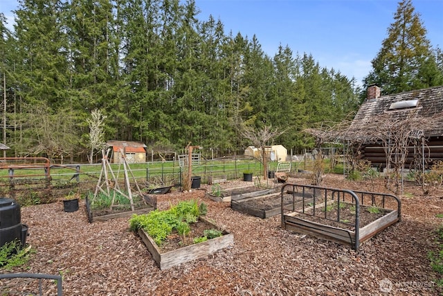 view of yard with an outbuilding, a vegetable garden, and fence