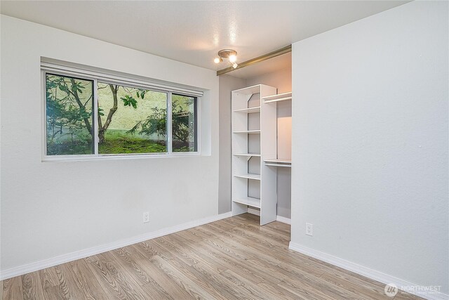 unfurnished bedroom featuring light wood finished floors and baseboards