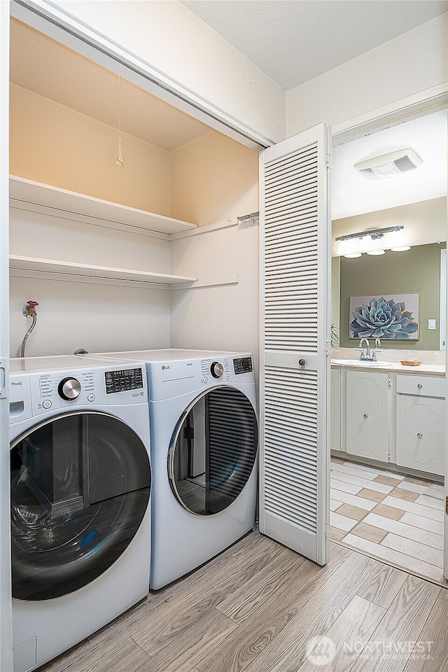 washroom with light wood finished floors and washing machine and dryer