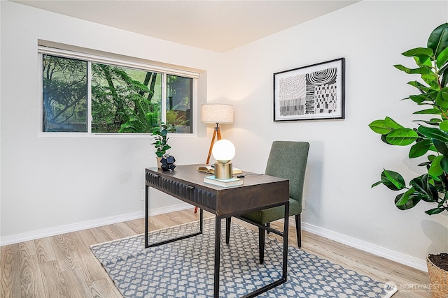 office area with baseboards and light wood-style flooring