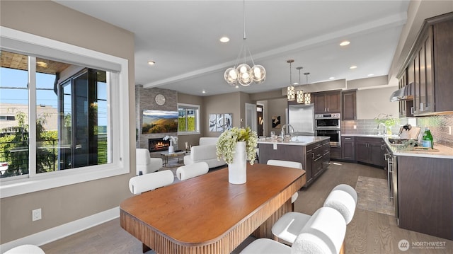 dining area with a healthy amount of sunlight, baseboards, dark wood-style flooring, and an inviting chandelier