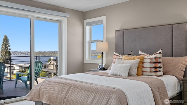 bedroom with a water view and access to outside