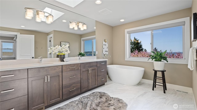 bathroom with a sink, a freestanding tub, double vanity, visible vents, and recessed lighting