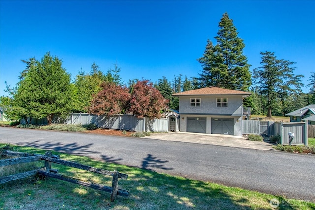 view of front facade with a garage, fence, and a gate