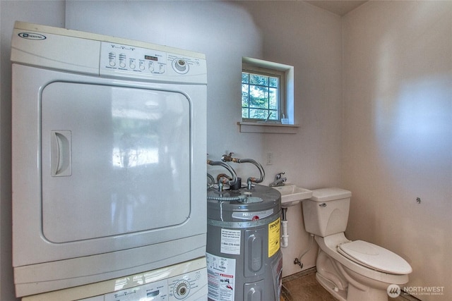 interior space featuring water heater, stacked washing maching and dryer, and laundry area
