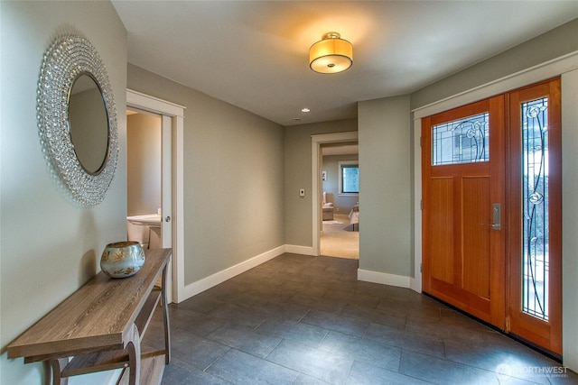 foyer with baseboards and recessed lighting