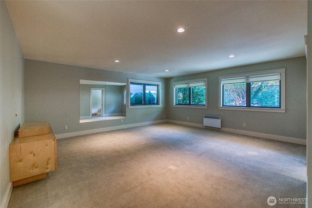 empty room featuring radiator heating unit, carpet flooring, baseboards, and recessed lighting