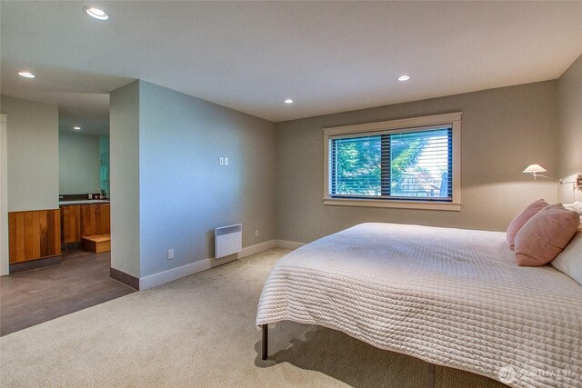 carpeted bedroom with ensuite bath, radiator heating unit, baseboards, and recessed lighting