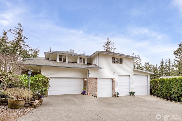 view of front of property featuring an attached garage, a chimney, concrete driveway, and brick siding