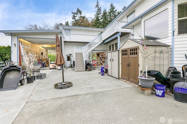 view of patio / terrace featuring a shed, an outdoor structure, and stairway