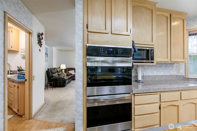 kitchen featuring tile counters, light wood-type flooring, appliances with stainless steel finishes, and light brown cabinets
