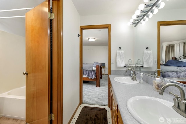 ensuite bathroom with double vanity, ensuite bathroom, a sink, and a bathtub