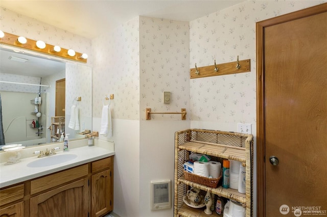 bathroom with walk in shower, vanity, visible vents, and wallpapered walls