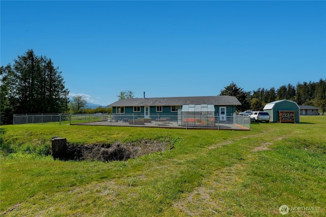 790 N Rhodefer Rd, Sequim, WA 98382 - back of house featuring a lawn, fence, an exterior structure, and an outbuilding