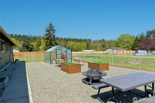 790 N Rhodefer Rd, Sequim, WA 98382 - view of patio with a vegetable garden, an outbuilding, an exterior structure, a view of trees, and a fenced backyard