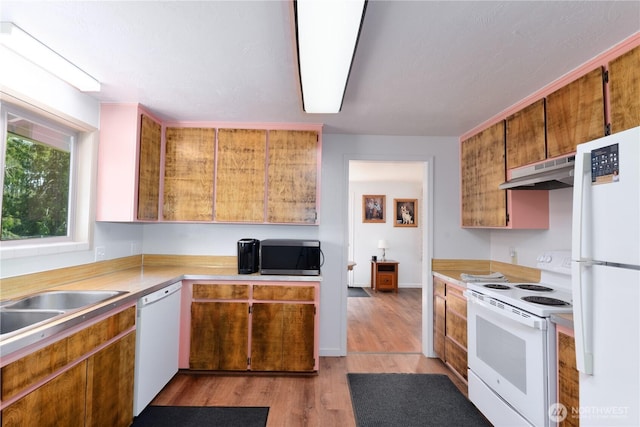 790 N Rhodefer Rd, Sequim, WA 98382 - kitchen with white appliances, light wood-style flooring, under cabinet range hood, light countertops, and brown cabinets