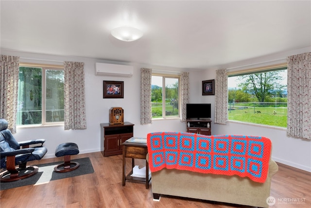 790 N Rhodefer Rd, Sequim, WA 98382 - bedroom with multiple windows, a wall unit AC, wood finished floors, and baseboards