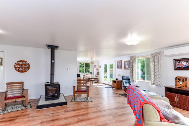 790 N Rhodefer Rd, Sequim, WA 98382 - living room featuring a wealth of natural light, light wood finished floors, an AC wall unit, and a wood stove