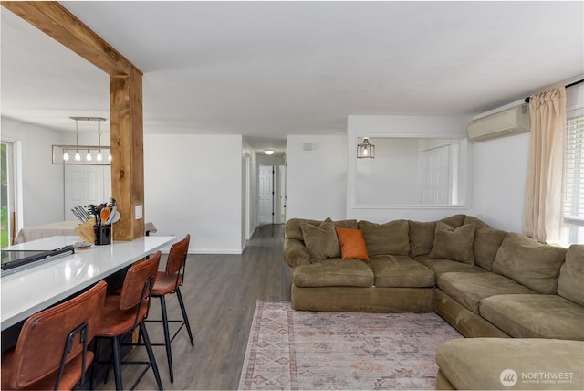 living area with wood finished floors, baseboards, and a wall mounted AC