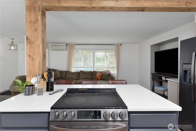 kitchen with stainless steel electric range oven, light countertops, an AC wall unit, black refrigerator with ice dispenser, and gray cabinets