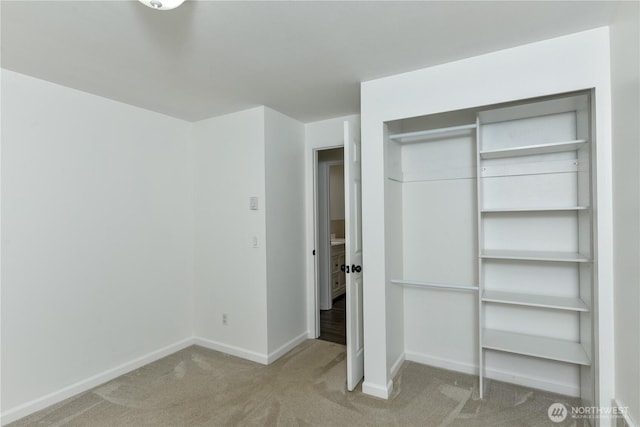 unfurnished bedroom with a closet, baseboards, and carpet flooring