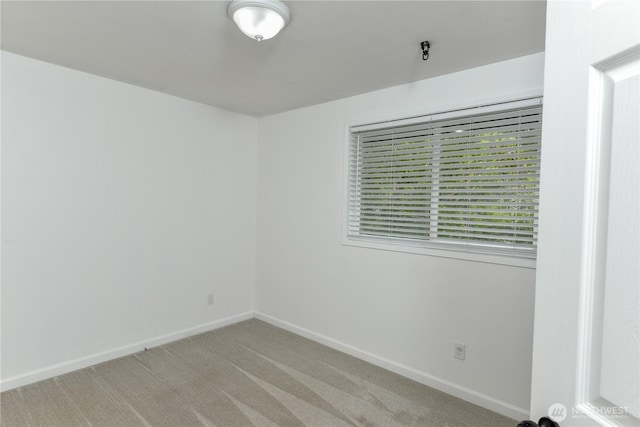 empty room with baseboards and light colored carpet