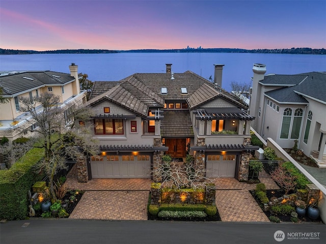 137 Lake Ave W, Kirkland, WA 98033 - view of front of home featuring an attached garage, stone siding, a tile roof, and decorative driveway