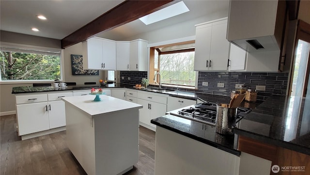 2205 135th Pl SE, Bellevue, WA 98005 - kitchen with a peninsula, range hood, a sink, decorative backsplash, and a skylight