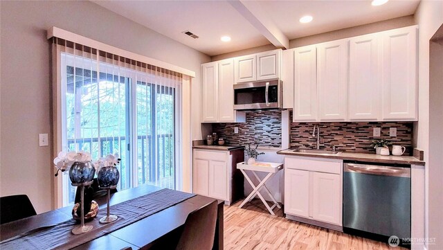 2205 135th Pl SE, Bellevue, WA 98005 - kitchen with stainless steel appliances, a sink, decorative backsplash, white cabinets, and light wood finished floors