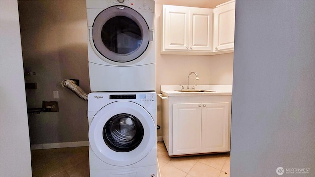2205 135th Pl SE, Bellevue, WA 98005 - laundry room featuring stacked washing machine and dryer, cabinet space, light tile patterned floors, and baseboards