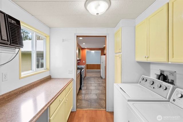 24709 148th Ave E, Graham, WA 98338 - laundry area featuring cabinet space, washer and clothes dryer, a textured ceiling, and light wood-style floors