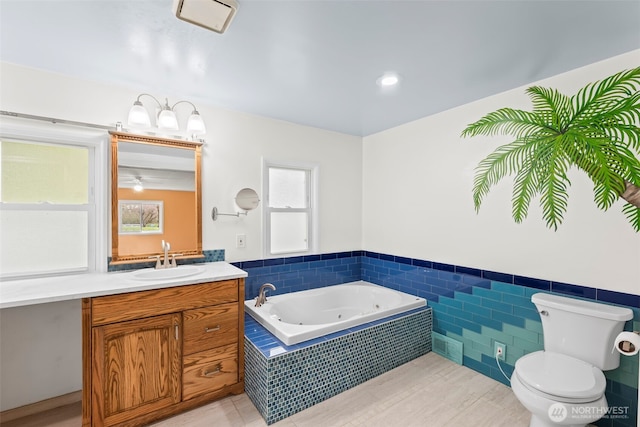 24709 148th Ave E, Graham, WA 98338 - bathroom with a jetted tub, toilet, a wainscoted wall, and vanity